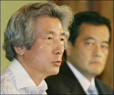 Japanese Prime Minister Junichiro Koizumi (L) answers questions while the head of the main opposition Democratic Party of Japan Katsuya Okada (R) looks on during a debate of six party leaders in Tokyo, August 29, 2005, ahead of early elections on September 11. 