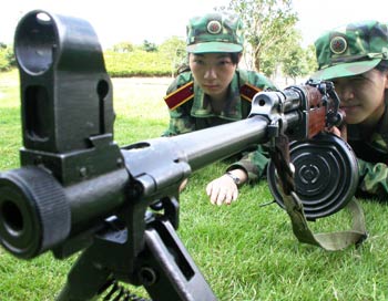 Two Chinese paramilitary soldiers learn to aim with a gun during training in Wenling, East China's Zhejiang Province September 25, 2005. The two soldiers are fresh college graduates. [newsphoto]