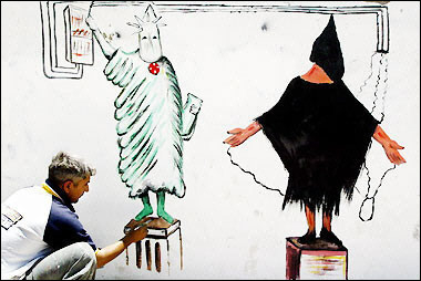 Iraqi artist Salah Edine Sallat puts the final touches to a wall painting based on the US Statue of Liberty and a widely published photograph of an abused detainee at the Abu Ghraib prison in Baghdad's Shiite neighborhood of Sadr City.