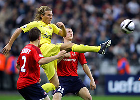 Diego Forlan (C) of Villarreal fights for the ball with Mathieu Debuchy (L) and Stephan Lichsteiner (R) of Lille during their Champions League group D soccer match at the Paris Stade de France stadium September 27, 2005.