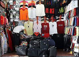 A vendor counts merchandise at his storefront in Beijing 05 September 2005.