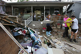 Yasmin Abbyad (R), 18, points to debris as Sarah Dunn (L), 17, and Kaitlyn Lombardo, 17, carry personal belongings from Lombardo's flood damaged home, on the second day since residents of the "Uptown" neighborhood were allowed to visit and stay in their homes, in New Orleans October 1, 2005. 