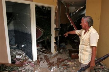 Juan Vargas looks at the room where his neighbor Mauren Arroyo was killed when the hillside above her house gave way due to heavy rains and crashed into the house in Naranjo, Costa Rica, 56 kilometers (35 miles) northwest of San Jose, Tuesday, Oct. 4, 2005. The Costa Rican government has declared a red alert for the Pacific region, fearing that rains caused by Hurricane Stan in Mexico could cause more damage to areas hard hit during last weeks flooding in Costa Rica.(AP