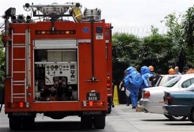 Firefighters wearing protection suits proceed to collect a suspicious package inside the Australian Embassy in Kuala Lumpur, Malaysia, Wednesday, Oct. 5, 2005.