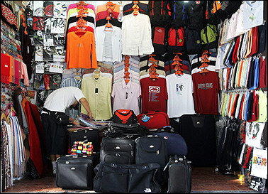A vendor counts merchandise at his storefront in Beijing 05 September 2005. 
