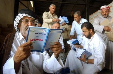 An elderly Iraqi looks at a copy of the country's new constitution at a distribution center in Najaf, Iraq, Monday Oct. 10 2005.