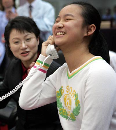 Nie Tianxiang talks with her father astronaut Nie Haisheng through a phone at the Beijing Aerospace Command and Control Center Wednesday October 12, 2005. Nie and Fu Junlong are orbiting the Earth in China's second manned spacecraft Shenzhou VI which was launched Wednesday morning. [Xinhua]