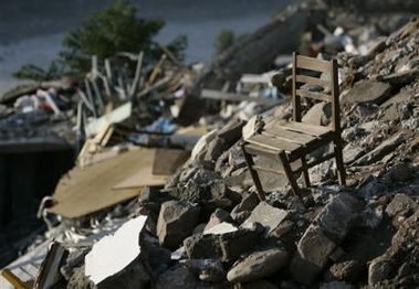 A chair is seen on the rubble of a collapsed apartment complex destroyed in last Saturday's earthquake in the northern Pakistani town of Muzaffarabad, Wednesday Oct. 12, 2005. Many bodies were still buried beneath razed buildings, and the United Nations warned of the threat of measles, cholera and diarrhea outbreaks among the millions of survivors.
