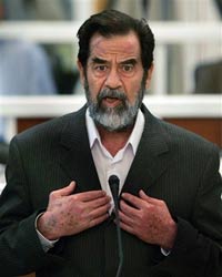 Saddam Hussein defiantly speaks to the Presiding Judge Rizgur Ameen Hana Al-Saedi as his trial begins in a heavily fortified courthouse in Baghdad's Green Zone October 19, 2005. [Reuters]