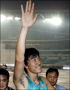 Olympic gold medallist Liu Xiang of China waves to the crowd after winning the final of the 110-meter hurdles at the 10th National Games of the People's Republic of China in Nanjing