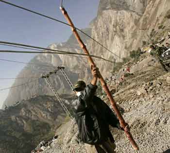 A Kashmiri worker tries to fix electricity cables in Muzaffarabad, capital of Pakistani-administered Kashmir October 22, 2005. [Reuters]