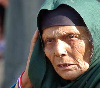 An elderly Kashmiri earthquake survivor, who lost her home after a massive earthquake, sits inside a tent at a refugee camp in Rawalpindi October 22, 2005. [Reuters]