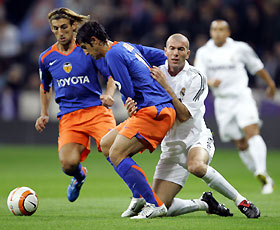 Real Madrid's Zinedine Zidane (front R) clashes with Valencia's Marco Antonio Caneira (C) as Valencia's Miguel Angel Angulo (L) looks on during their Spanish First Division soccer match at Madrid's Santiago Bernabeu stadium October 23, 2005.
