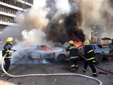 Iraqi firefighters try to extinguish burning vehicles at the site of a suicide attack in Baghdad, Iraq, Sunday Oct. 23 2005. A suicide car bomb in central Baghdad hit two police vehicles in Al-Tahrir Square, killing two officers and two civilians, said police Maj. Mohammed Younis.(AP