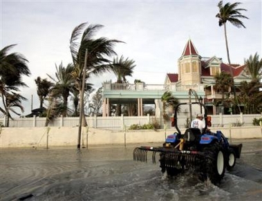 A vehicle drives down an already-flooded street near the southernmost point in Key West, Fla. Sunday, Oct. 23, 2005.