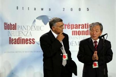 Canadian Health Minister Ujjal Dosanjh (L) listens to World Health Organization Director-General Lee Jong-wook speak on the first day of a two-day health conference in Ottawa October 24, 2005. 