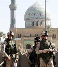 The 14th of Ramadan Mosque is seen in the background as US soldiers survey the scene of Monday's suicide car bombs attack, in Baghdad, Iraq, Tuesday, Oct. 25, 2005. A U.S. Army sergeant died of wounds suffered in Iraq, the Pentagon announced Tuesday. The death brought to 2,000 the number of U.S. military members who have died since the start of the Iraq conflict in 2003. (AP