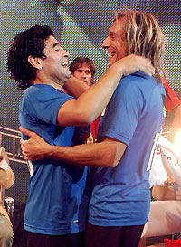 Argentine soccer legend Diego Maradona (L) embraces former Argentine soccer star Claudio Caniggia during Maradona's weekly television show "La noche del 10" (The Night of the 10) in Buenos Aires September 26, 2005. Picture taken September 26, 2005. 