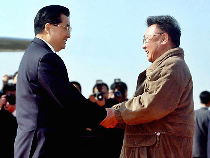 President Hu Jintao (left) shakes hands with the Democratic People's Republic of Korea leader Kim Jong-Il upon his arrival at Pyongyang Airport on Friday. Hu arrived in Pyongyang for a three-day official visit.(