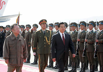 President Hu Jintao (left) shakes hands with the Democratic People's Republic of Korea leader Kim Jong-Il upon his arrival at Pyongyang Airport on Friday. Hu arrived in Pyongyang for a three-day official visit.(