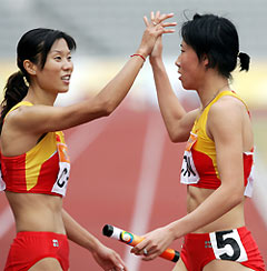 Huang Xiaoxiao (R) is congratulated by team mate Xie Qing after China won the gold medal for the women's 4x400 metre relay final at the 4th East Asian Games in Macau November 4, 2005. Hung finished off the last leg after Xie started the race for China. 