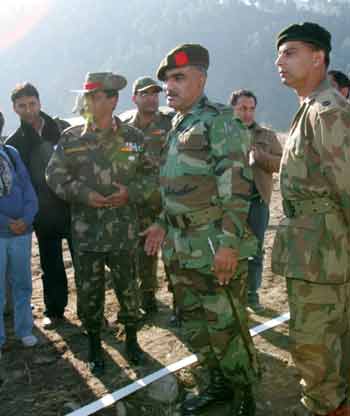 Pakistani army officers and an Indian army officer (L) talk over the Line of Control (LoC) in Titrinote, Pakistan-administered Kashmir, about 180-km (111.8 miles) east of Islamabad, November 7, 2005. Pakistan and India open one checkpoint of the LoC on Monday between Pakistan-administered Kashmir's Titrinote and Indian-administered Kashmiri's Poonch. The Pakistani proposal to open five points on the old rivals' disputed border in Kashmir appears more of a symbolic gesture of friendship, rather than something that will make a big difference for efforts to bring relief to survivors.