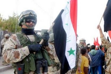 An Iraqi soldier holds the Iraqi flag in a secured area of Husaybah during Operation Steel Curtain in this handout photo released November 7, 2005.