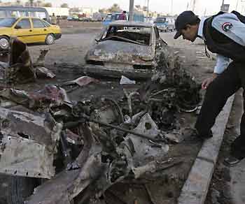 An Iraqi policeman inspects the remains of a car bomb that exploded on Wednesday night in a north Baghdad district November 10, 2005. 