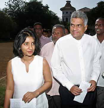 Sri Lankan presidential candidate and leader of the main opposition party, Ranil Wickremesinghe (R), and his wife Maithree walk toward a polling station in Colombo, Sri Lanka, November 17, 2005.