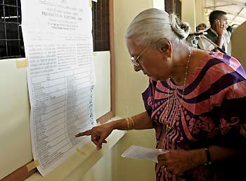 A Sri Lankan woman looks at the name list of presidential candidates at the entrance of a polling station in Colombo November17, 2005. Sri Lankan began casting their votes in a close-fought presidential poll on Thursday seen as a referendum on how to turn a truce with Tamil rebels into lasting peace and develop a rural economy battered by two decades of war.