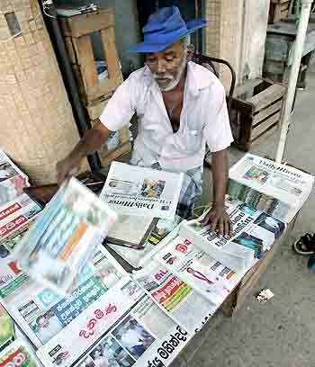 A newspaper vendor arranges newspapers in Colombo November 18, 2005. Prime Minister Mahinda Rajapakse claimed victory on Friday in Sri Lanka's presidential poll after taking a slim lead with more than half of votes counted, his office said.