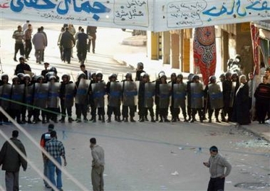 Egyptian anti-riot soldiers block a road leading to a polling station, in Damanhur, 140 kilometers (85 miles) north of Cairo, Egypt, during the second round of the Egyptian parliamentary elections Sunday, Nov. 20, 2005. Widespread violence marred the second round of Egypt's parliamentary vote Sunday, with a campaign worker killed in the Mediterranean port city of Alexandria. [AP]