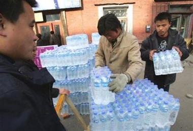 Workers load bottled water on to a cart in Harbin, in northeast China's Heilongjiang province Thursday, Nov. 24, 2005. Authorities have shut down the city's water supply due to contamination of the Songhua river, from which Harbin gets its water, after an explosion in a chemical plant in a city up river. [AP] 
