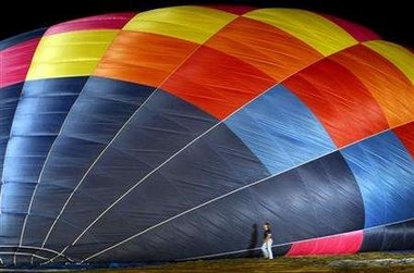 A worker passes by Industrialist Vijaypat Singhania's hot air balloon during its preparation for take off in Mumbai November 26, 2005.