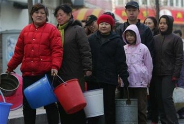Residents line up to receive water in Harbin, the capital of northeastern Heilongjiang province, November 25, 2005.