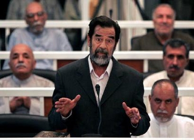 Saddam Hussein speaks to the Presiding Judge Rizgur Ameen Hana Al-Saedi as his trial begins in a heavily fortified courthouse in Baghdad's Green Zone in this October 19, 2005 file photo.