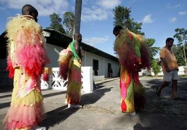 Cuban dancers wait to go onstage for an event marking World AIDS day as a HIV positive patient walks past in an AIDS sanatorium outside Havana December 1, 2005.
