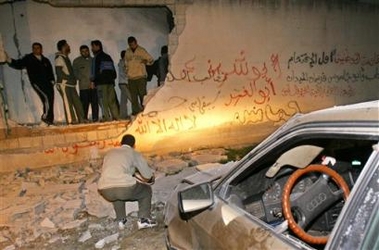 Palestinians look at the damage in a building used by an association linked to the Islamic Jihad movement after it was hit by an Israeli missile strike early Sunday Dec. 4, 2005.