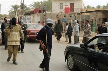 Hooded men carrying assault rifles check passing cars in Ramadi, Iraq Monday, Dec. 12, 2005, ahead of the Dec. 15 parliamentary elections, which will select a National Assembly that will serve for four years. 