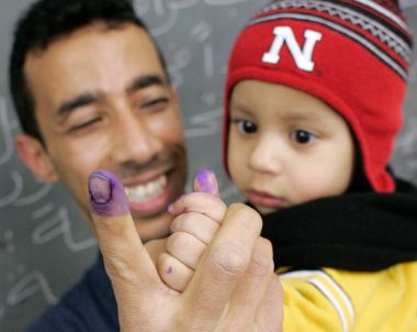 Aqui Al-Hirez and his 13-month-old son Mussilm show off their inked index fingers after Aquil voted in Chicago December 13, 2005.