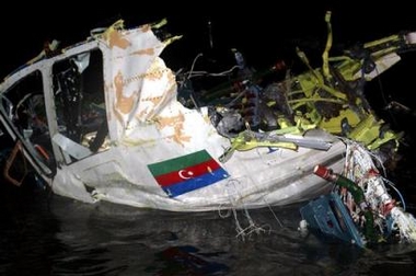 The wreckage of an Azerbaijan Airlines passenger plane, which crashed late Friday seen at the crash site, in the Sabunchi region north of the capital, Baku, early Saturday, Dec. 24, 2005, with an Azerbaijani flag on the wreckage.