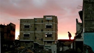 A Palestinian boy walks near destroyed houses near the Rafah border between Egypt and the southern Gaza Strip December 26, 2005. 