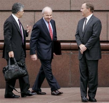 Former Enron CEO Jeffrey Skilling, right, waits to cross the street as Enron founder Kenneth Lay, center, talks with Skilling's lawyer, Daniel Petrocelli, left, as they make their way to the federal courthouse for a pretrial hearing Friday, Dec. 16, 2005 in Houston. 