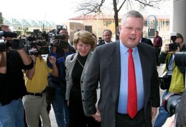 Former Enron Chief Accounting Officer Richard Causey and wife Bitsy enter the Houston Federal Courthouse on his way to pleading guilty to securities fraud in a plea bargain with prosecutors in Houston December 28, 2005. 