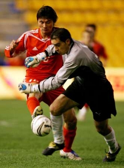 China's Li Yi (back) fights for the ball with Andalucia's Jose Antonio Luque before scoring on it during their friendly soccer match at the Ramon de Carranza Stadium in Cadiz, southern Spain December 28, 2005. 