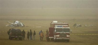 Officials investigate the scene of a small plane crash Thursday, Dec. 29, 2005, in a field near about one mile south of the Millard Airport in southwest Omaha, Neb.