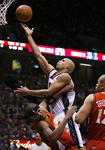 New Jersey Nets forward Richard Jefferson (C) makes a layup as he crashes into Atlanta Hawks forward Josh Smith (L) as he drives by forward John Thomas (R) in the fourth quarter of their NBA game in East Rutherford, New Jersey December 30, 2005.