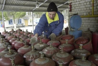 A Ukrainian worker prepares to load empty gas containers at a gas station in the town of Brovary that works with small consumers such as householders, 20 km (12.5 miles) northwest of Kiev on Tuesday, Jan. 3, 2006.