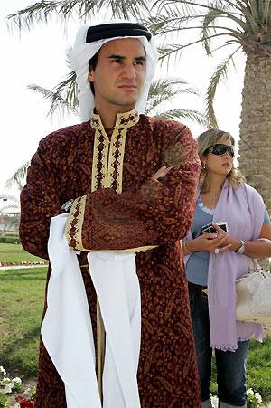 World number one tennis player Roger Federer (L) of Switzerland poses wearing traditional Qatari dress during a desert trip, on the second day of the Qatar Open tennis tournament, in the outskirts of Doha January 3, 2006. 