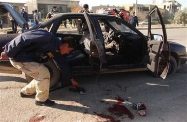 Iraqi police retrieve personal articles from victims of a roadside bomb, Wednesday, Jan. 4, 2006, in Kirkuk, Iraq.